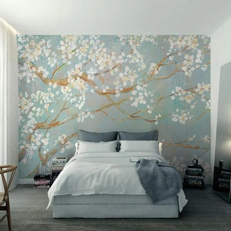 Papier peint panoramique Cerisier en fleurs peint à l'huile : branches de cerisier en fleurs crème sur fond bleu-vert poudré, rendu peinture à l'huile, posé dans une chambre