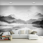 Papier peint panoramique Lac et montagnes à l'encre : lac et montagnes dans la brume, lavis d'encre noir et gris, posé dans un salon