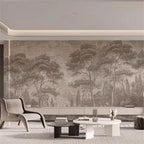 Papier peint panoramique Forêt de pins gravée taupe : forêt de pins gravée taupe sur tout un mur de salon, fauteuil lounge et tables basses
