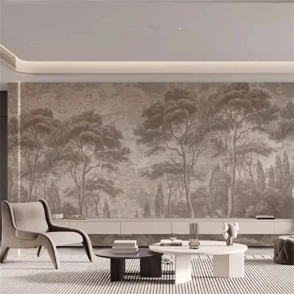 Papier peint panoramique Forêt de pins gravée taupe : forêt de pins gravée taupe sur tout un mur de salon, fauteuil lounge et tables basses
