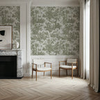Papier peint panoramique Toile de Jouy vert sauge : toile de Jouy vert sauge au-dessus d'un soubassement blanc, cheminée en marbre et deux fauteuils