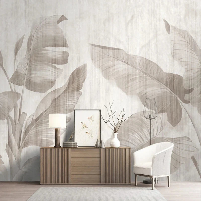 Papier peint panoramique Bananiers ivoire : feuilles de bananier ivoire et gris perle sur fond crème, posé dans un salon