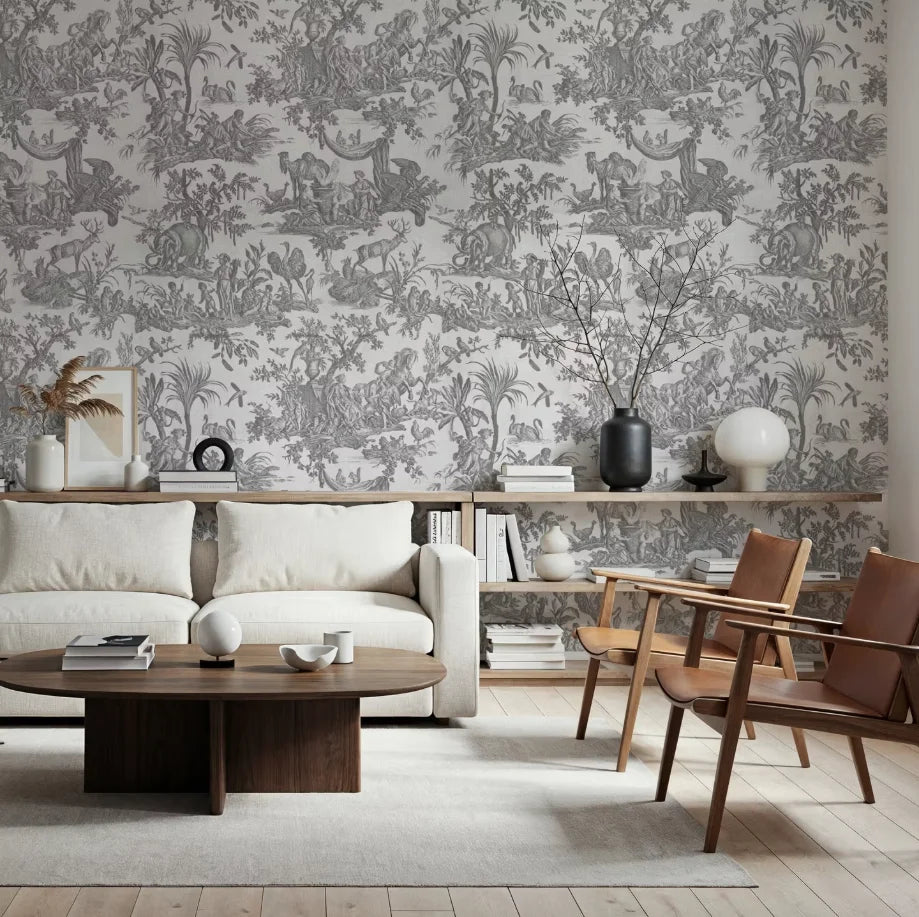 Papier peint panoramique Toile de Jouy gris perle : toile de Jouy gris perle derrière un canapé blanc, une table basse en bois et deux fauteuils en cuir