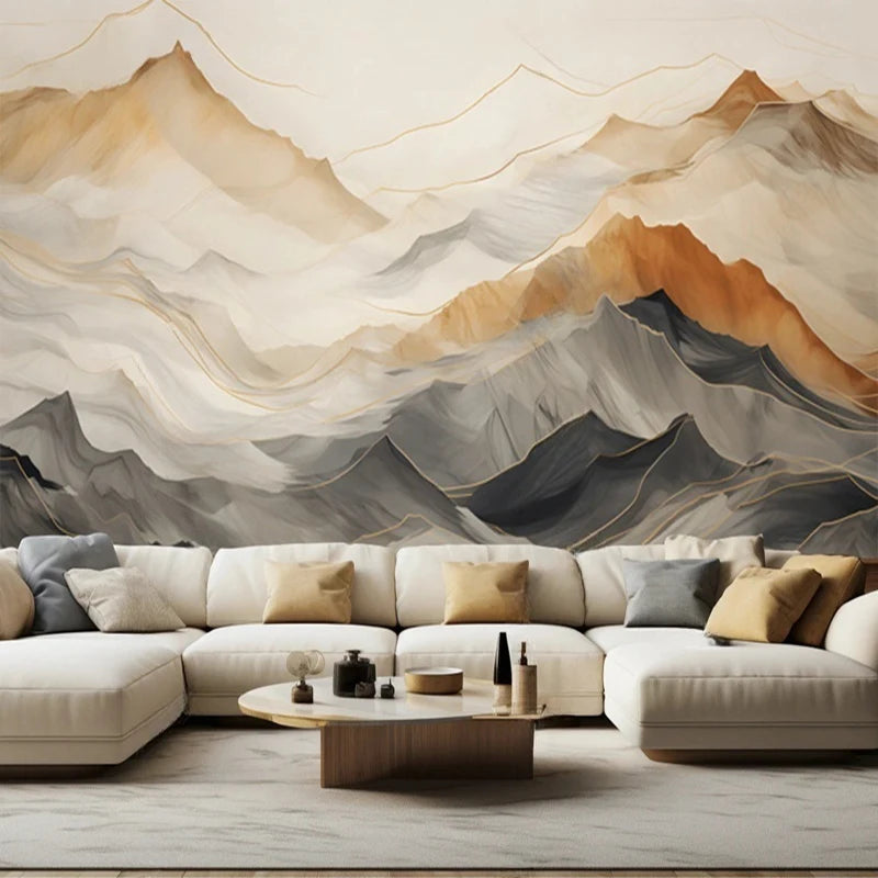 Papier peint panoramique Montagnes aquarelle ocre et ardoise : crêtes de montagnes superposées en ocre, gris ardoise et crème, derrière un grand canapé d'angle
