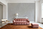 Papier peint effet plâtre peigné gris perle : effet plâtre peigné gris perle derrière un canapé en velours vieux rose et un fauteuil en toile