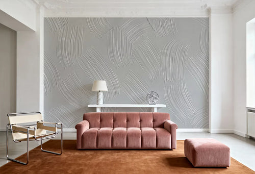 Papier peint effet plâtre peigné gris perle : effet plâtre peigné gris perle derrière un canapé en velours vieux rose et un fauteuil en toile