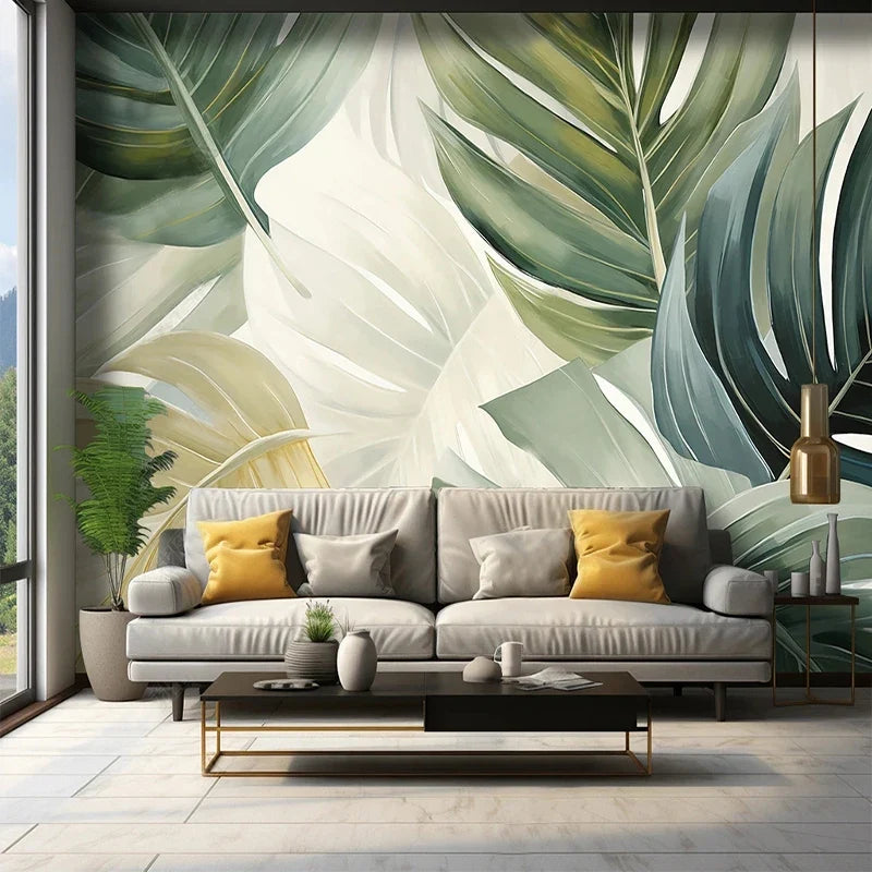 Papier peint panoramique Grandes feuilles vert sauge : grandes feuilles de monstera vert sauge et vert bouteille sur fond crème, posé dans un salon