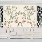 Papier peint panoramique Roses grimpantes et oiseaux crème : arceaux de roses grimpantes rose ancien et petits oiseaux bleus sur fond crème, derrière un canapé blanc