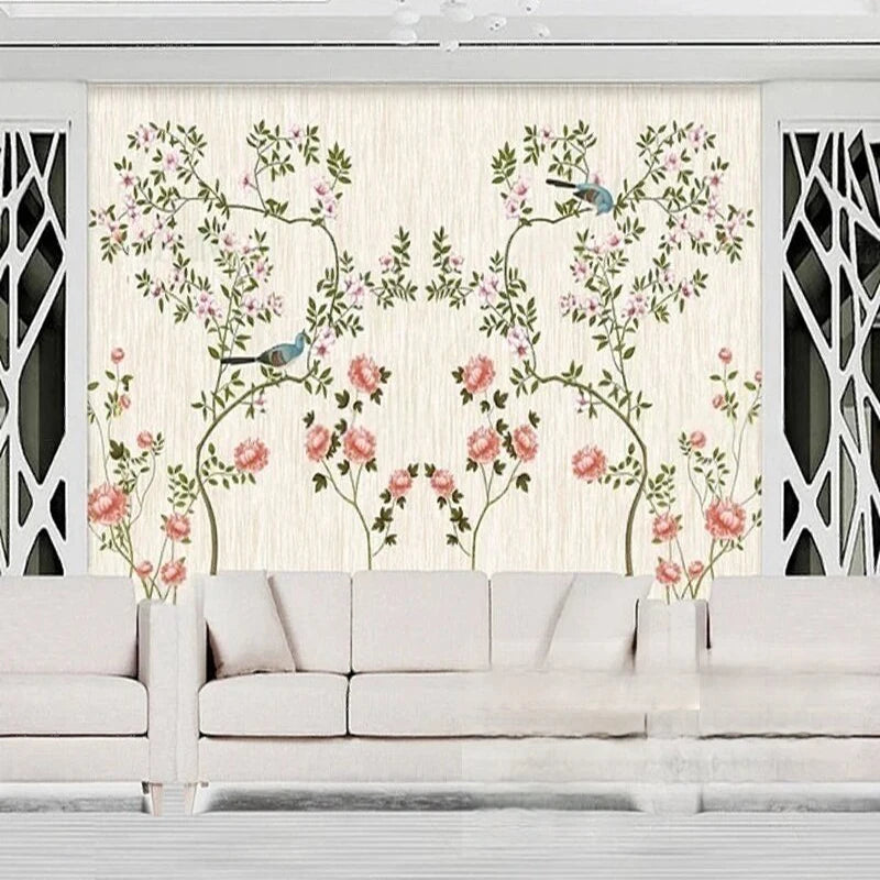 Papier peint panoramique Roses grimpantes et oiseaux crème : arceaux de roses grimpantes rose ancien et petits oiseaux bleus sur fond crème, derrière un canapé blanc