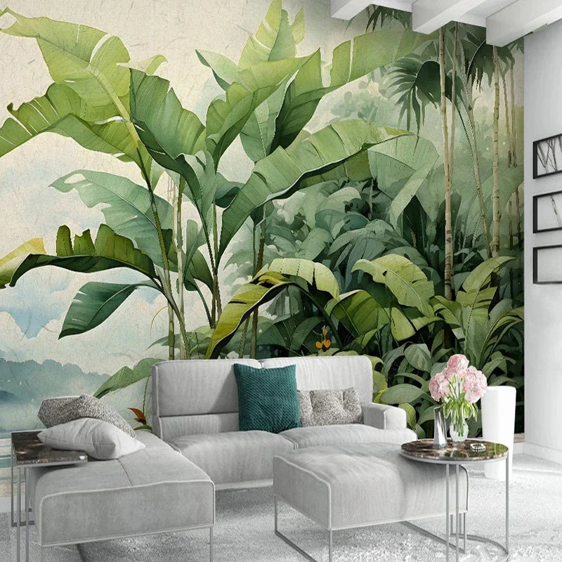 Papier peint panoramique Jungle nordique aquarelle : bananiers verts devant un lac et des montagnes bleu brume, à l'aquarelle, posé dans un salon
