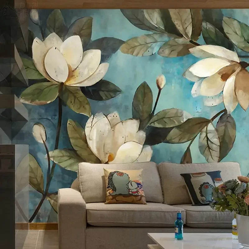 Papier peint panoramique Magnolias peints bleu canard : magnolias peints sur fond bleu canard derrière un canapé