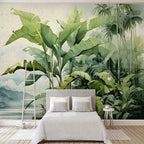 Papier peint panoramique Jungle nordique aquarelle : bananiers verts devant un lac et des montagnes bleu brume, à l'aquarelle, posé dans une chambre