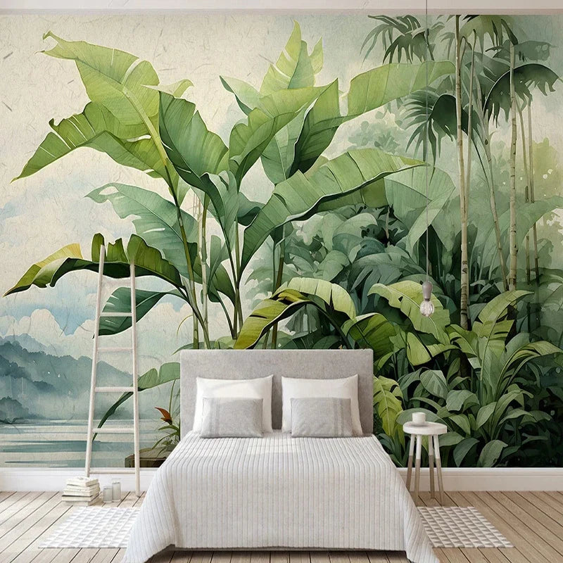 Papier peint panoramique Jungle nordique aquarelle : bananiers verts devant un lac et des montagnes bleu brume, à l'aquarelle, posé dans une chambre