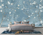 Papier peint panoramique Chinoiserie cerisier bleu brume : branches de cerisier en fleurs et oiseaux sur fond bleu brume, posé dans une chambre