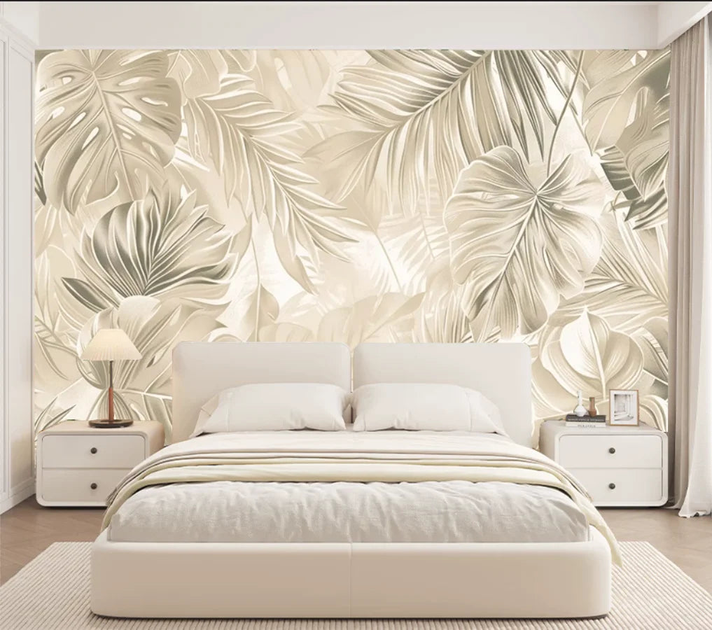 Papier peint panoramique Feuillage lin doré : grandes feuilles tropicales ton sur ton lin et sable, posé derrière une tête de lit