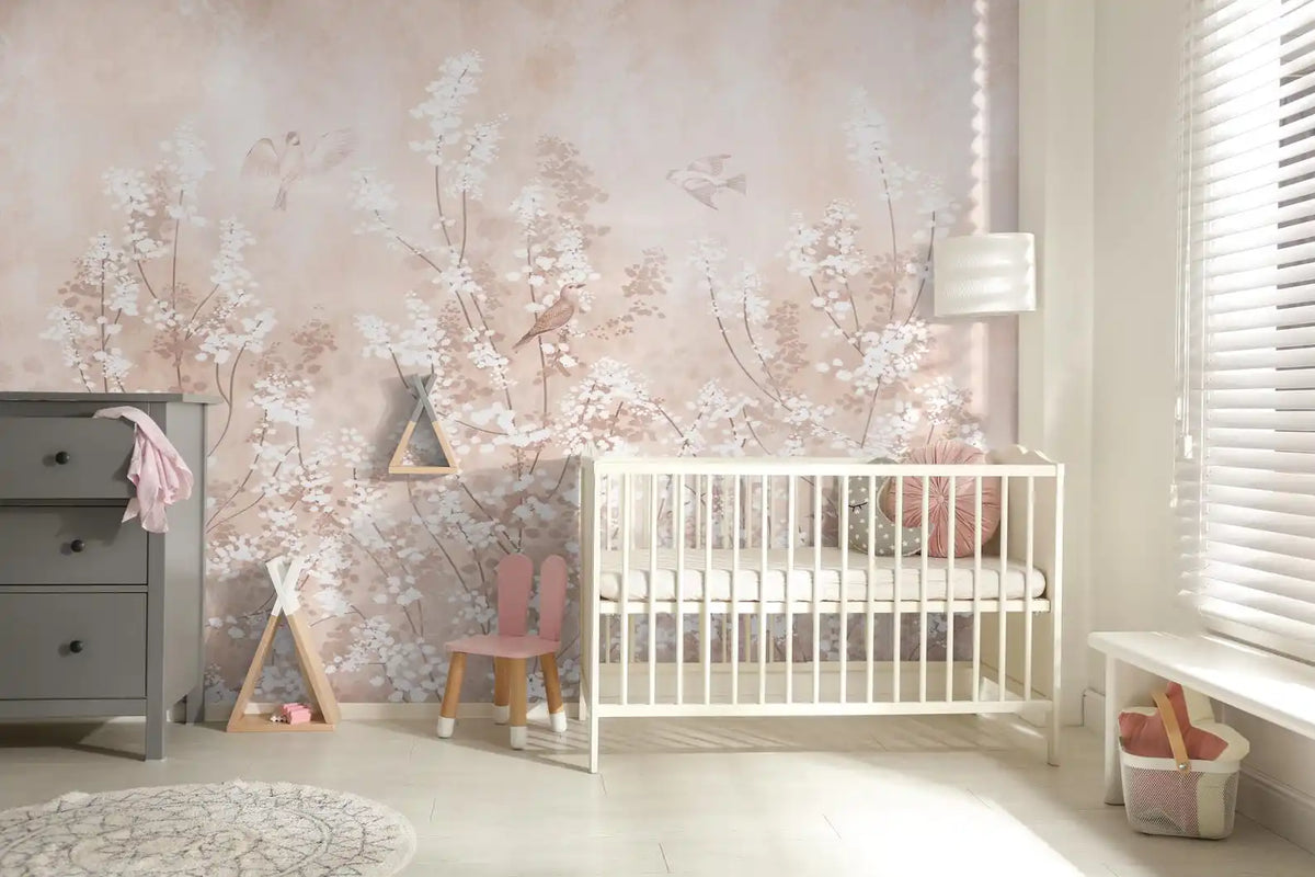 Papier peint panoramique Chinoiserie fleurs blanches rose poudré : chinoiserie aux arbustes en fleurs blanches sur fond rose poudré dans une chambre de bébé, lit à barreaux blanc
