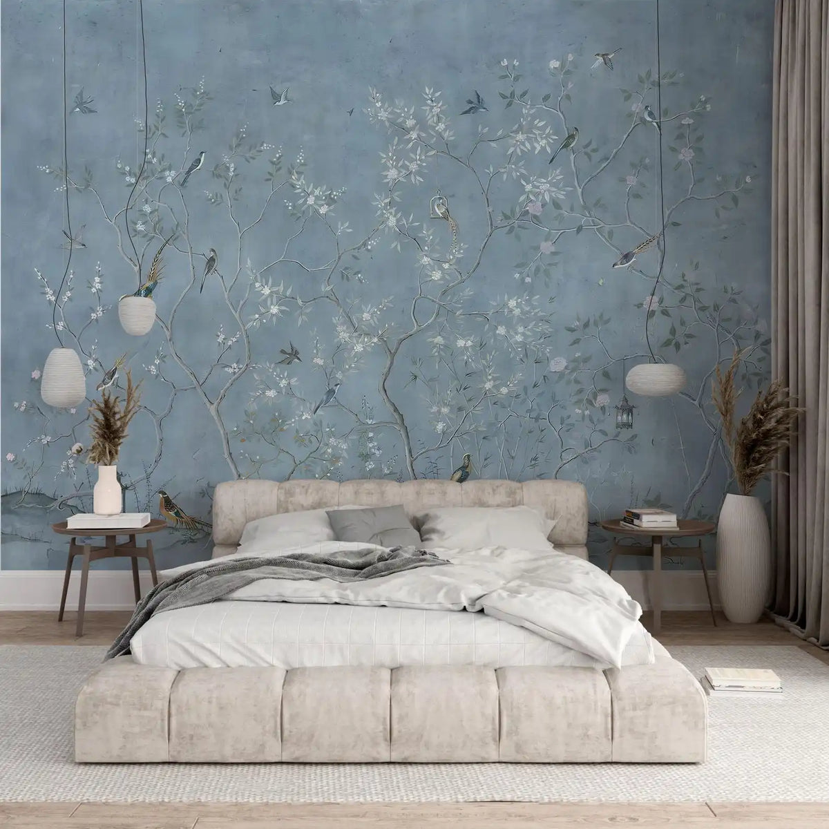 Papier peint panoramique Chinoiserie arbustes et oiseaux bleu brume : chinoiserie aux fins arbustes et oiseaux sur fond bleu brume, derrière un lit capitonné crème