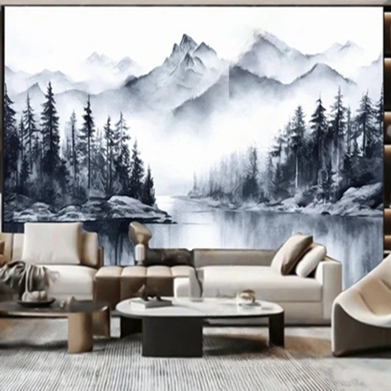 Papier peint panoramique Montagnes et sapins à l'encre : montagnes, sapins et lac peints à l'encre gris-bleu sur fond blanc, posé derrière un canapé