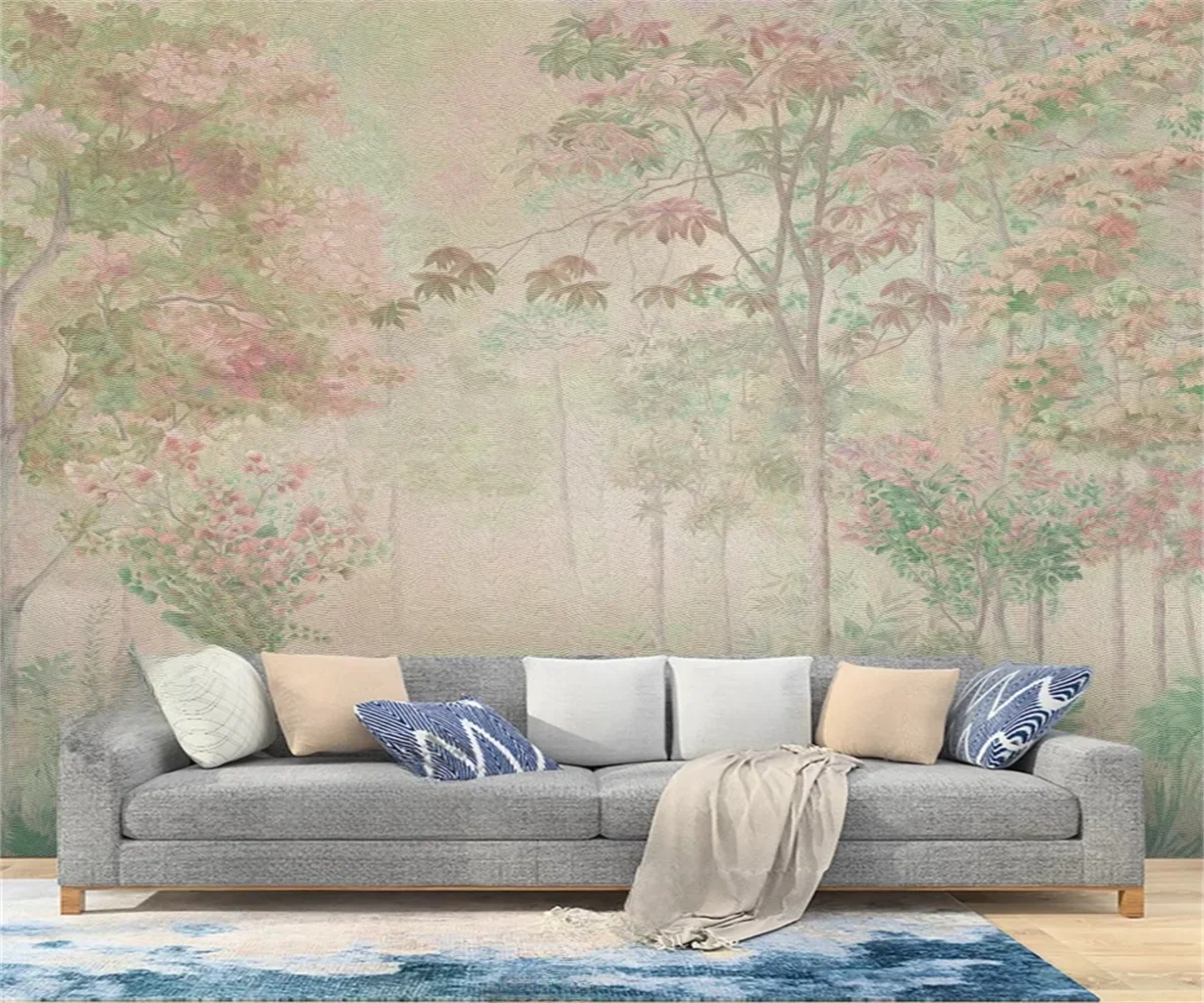 Papier peint panoramique Sous-bois fleuri vintage : forêt peinte aux feuillages vieux rose et vert passé, posé dans un salon