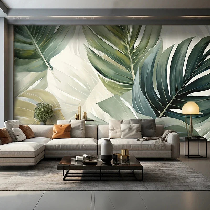 Papier peint panoramique Grandes feuilles vert sauge : grandes feuilles de monstera vert sauge et vert bouteille sur fond crème, posé dans un salon