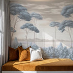 Papier peint panoramique Pins parasols peints bleu brume : pins parasols peints bleu brume derrière une banquette ocre et des coussins en velours