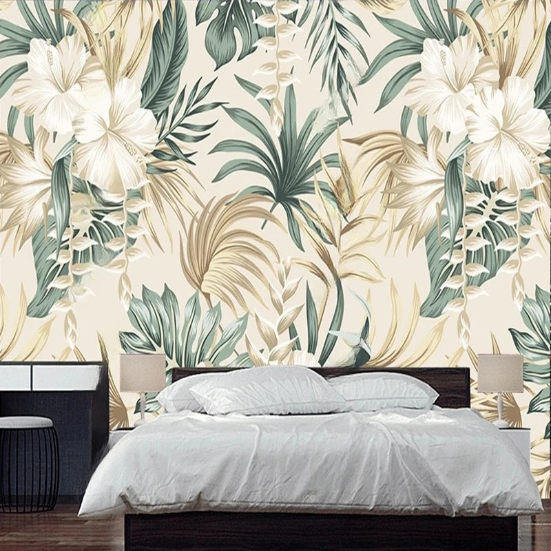 Papier peint panoramique Hibiscus et feuillages sauge : fleurs d'hibiscus blanches, feuillages vert sauge et palmes sable sur fond crème, derrière un lit