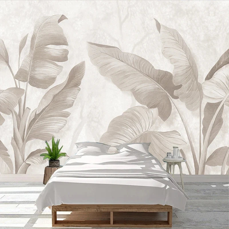 Papier peint panoramique Bananiers ivoire : feuilles de bananier ivoire et gris perle sur fond crème, posé dans une chambre