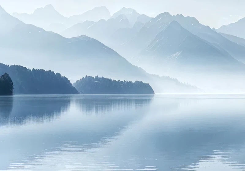 Papier peint panoramique Lac de montagne bleu brume : détail du motif, rive boisée et reflets sur le lac