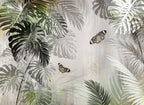 Papier peint panoramique Jungle grisée aux papillons : vue du motif, feuilles de monstera et palmes en gris, blanc et vert olive, papillons sur fond patiné