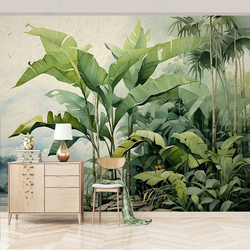 Papier peint panoramique Jungle nordique aquarelle : bananiers verts devant un lac et des montagnes bleu brume, à l'aquarelle, posé dans un salon