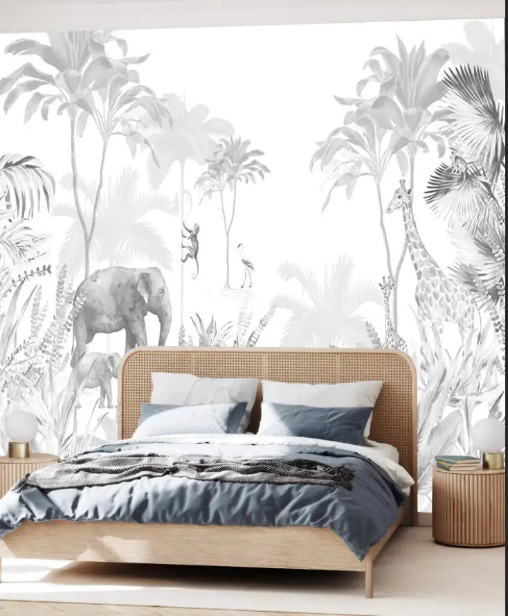Papier peint panoramique Jungle et animaux noir et blanc : jungle esquissée en gris et blanc, éléphants, girafe et zèbre, posé derrière une tête de lit en cannage