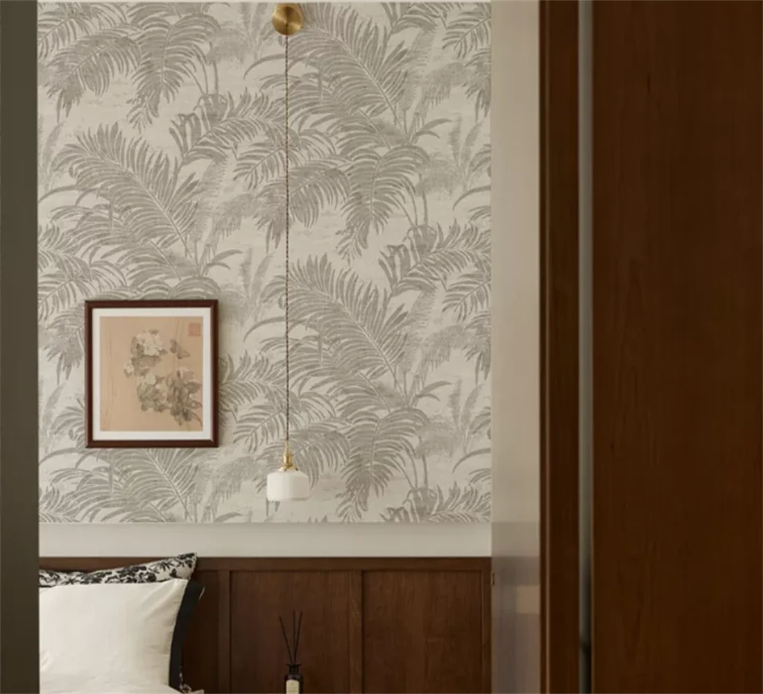 Papier peint effet palmes ton sur ton gris perle : effet palmes ton sur ton gris perle dans une chambre, suspension en verre et boiseries sombres