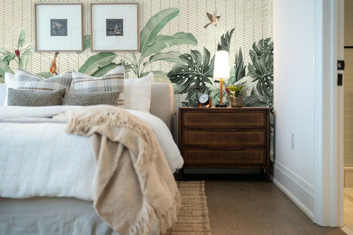 Papier peint panoramique Bananiers et oiseaux sur fond chevron posé derrière la tête de lit d’une chambre