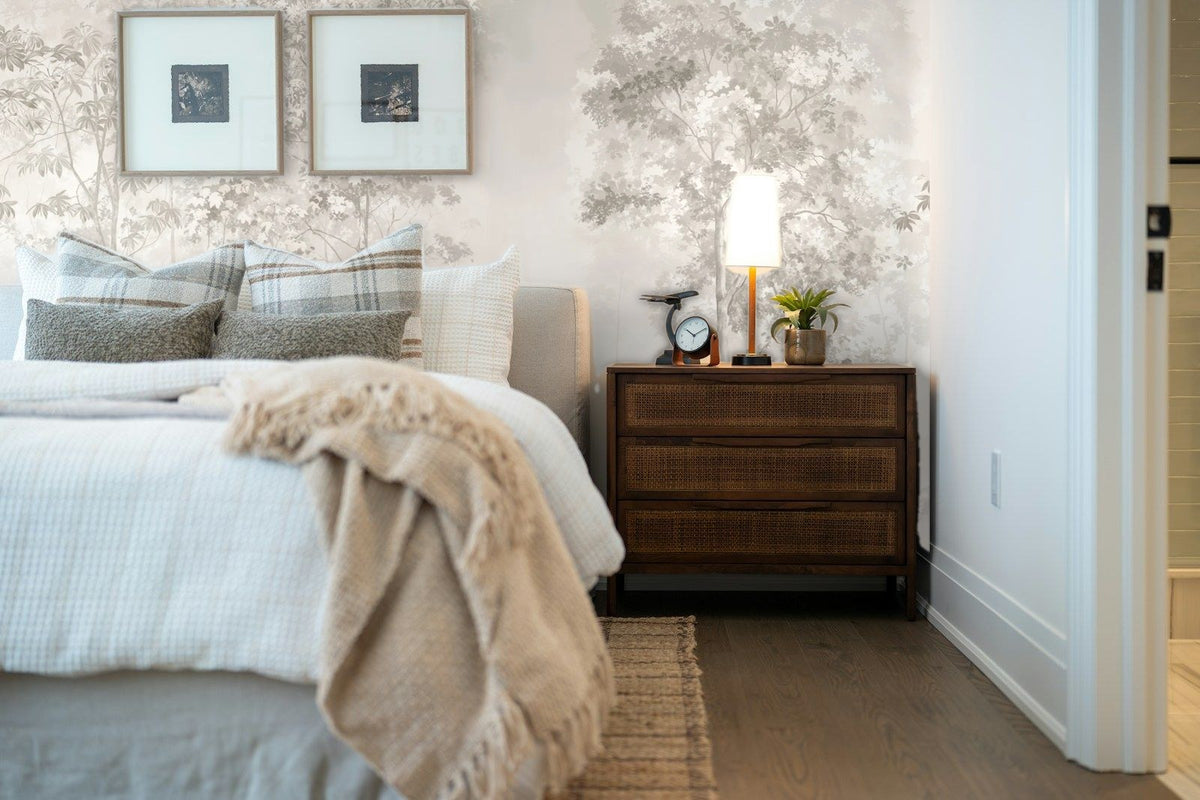 Papier peint panoramique Bosquets fleuris dans la brume crème posé derrière la tête de lit d’une chambre