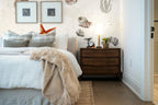 Papier peint panoramique Coquillages et étoile de mer fond sable posé derrière la tête de lit d’une chambre