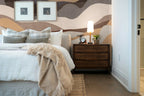 Papier peint panoramique Dunes abstraites taupe et sable posé derrière la tête de lit d’une chambre