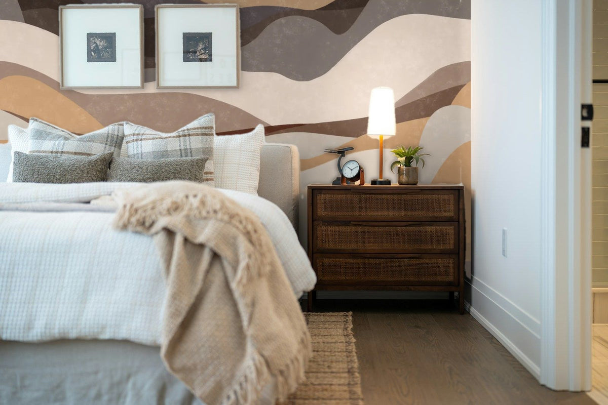 Papier peint panoramique Dunes abstraites taupe et sable posé derrière la tête de lit d’une chambre