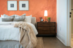 Papier peint effet enduit terre cuite posé derrière la tête de lit d’une chambre