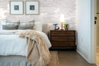 Papier peint effet nuages gravés gris rosé posé derrière la tête de lit d’une chambre