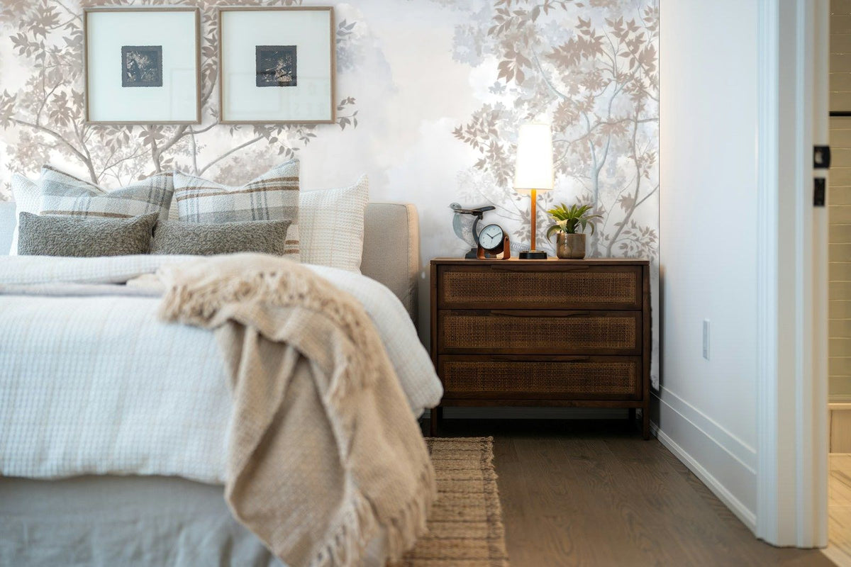 Papier peint panoramique Faisans et arbres bleu brume posé derrière la tête de lit d’une chambre