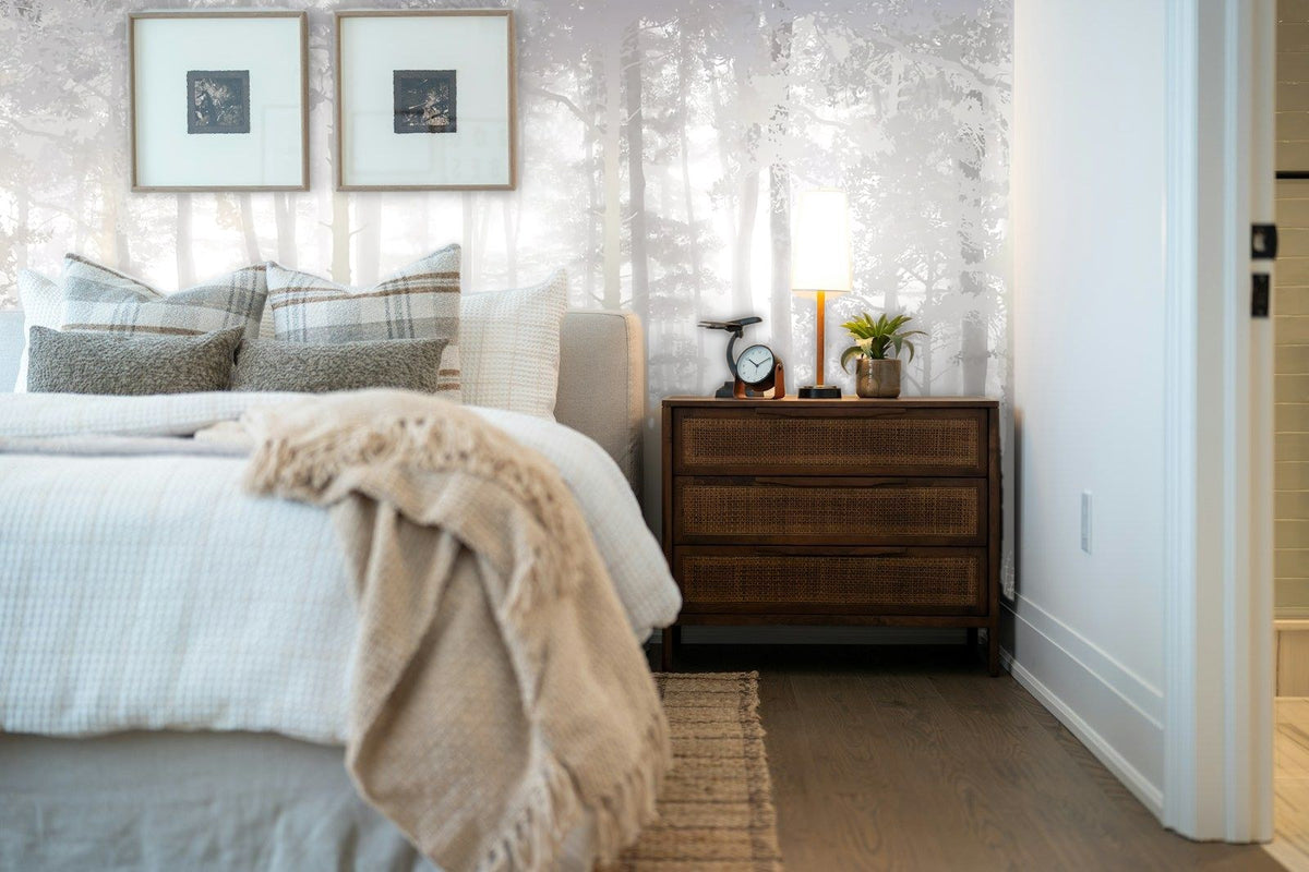 Papier peint panoramique Forêt de pins dans la brume gris perle posé derrière la tête de lit d’une chambre
