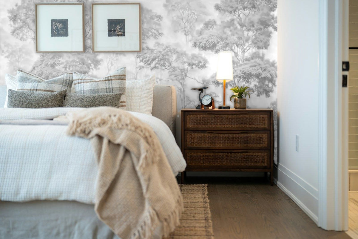Papier peint panoramique Forêt gravée gris perle dans la brume posé derrière la tête de lit d’une chambre