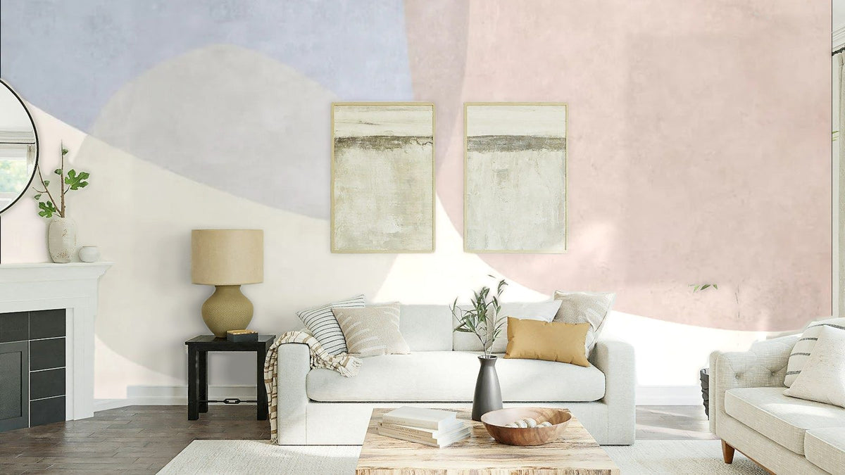 Papier peint panoramique Formes organiques bleu brume et rose poudré posé au-dessus du canapé d’un séjour