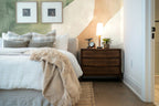 Papier peint panoramique Formes organiques vert sauge posé derrière la tête de lit d’une chambre
