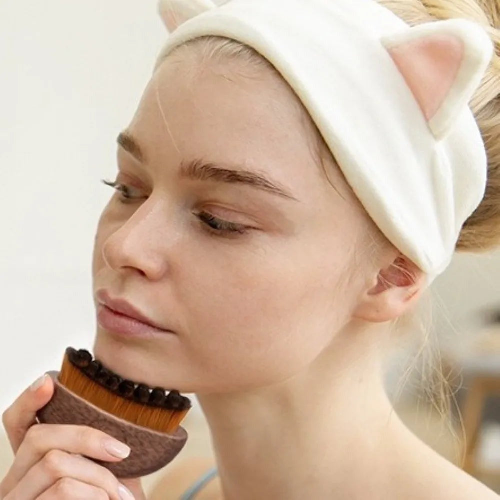 Femme passant la brosse de drainage lymphatique le long de la mâchoire, du menton vers l'oreille