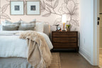 Papier peint panoramique Grandes fleurs au trait rose poudré posé derrière la tête de lit d’une chambre