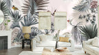 Papier peint panoramique Jungle aux oiseaux gris et rose poudré posé au-dessus du canapé d’un séjour