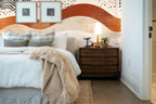 Papier peint panoramique Vagues terracotta et crème posé derrière la tête de lit d’une chambre